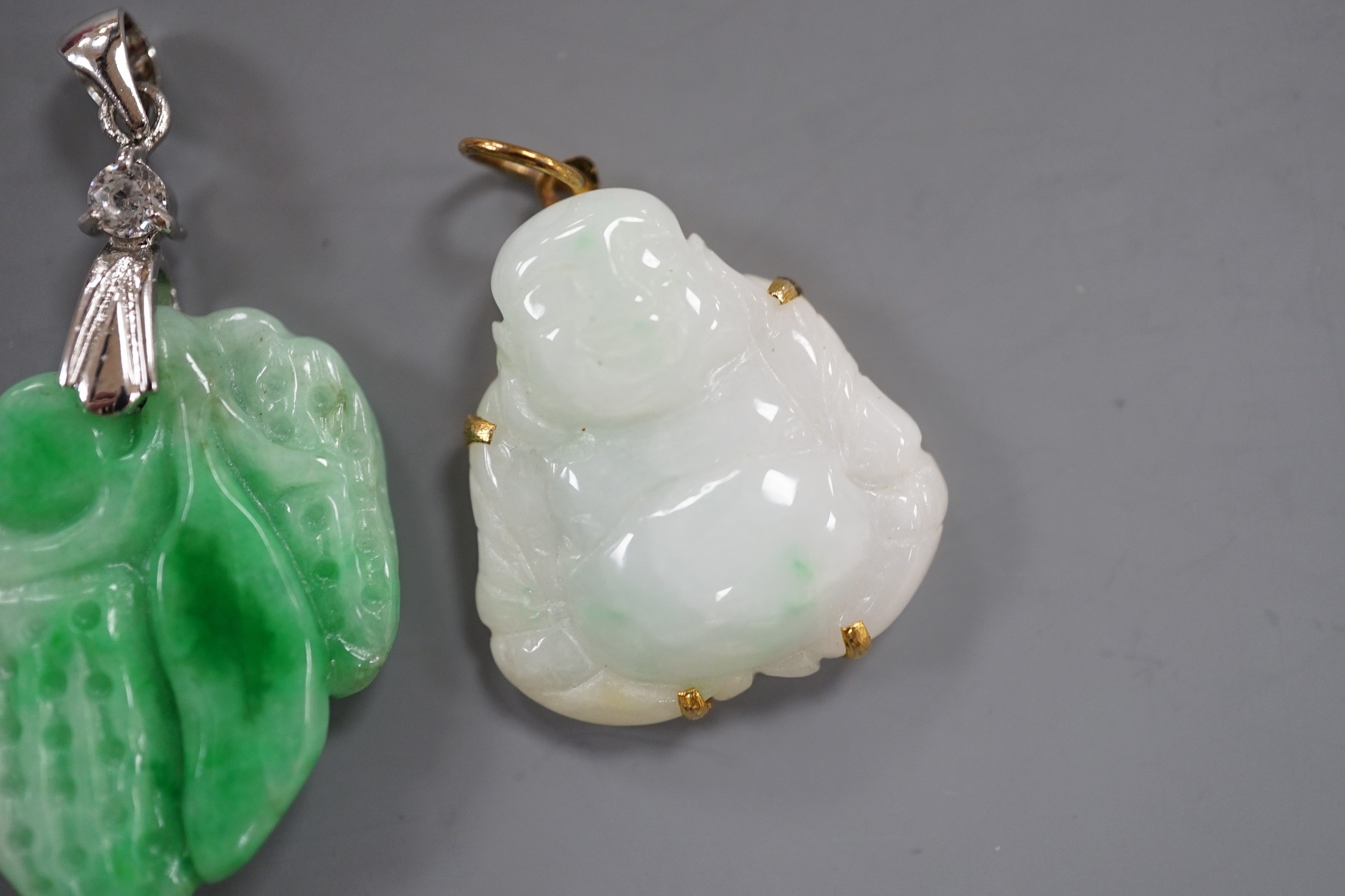 A modern 18k gold plated and simulated diamond mounted carved jade pendant, overall 39mm and a gilt metal mounted carved jade pendant.